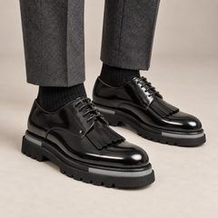 DIVINCH black glossy kiltie fringe Derby shoes worn with tailored charcoal trousers