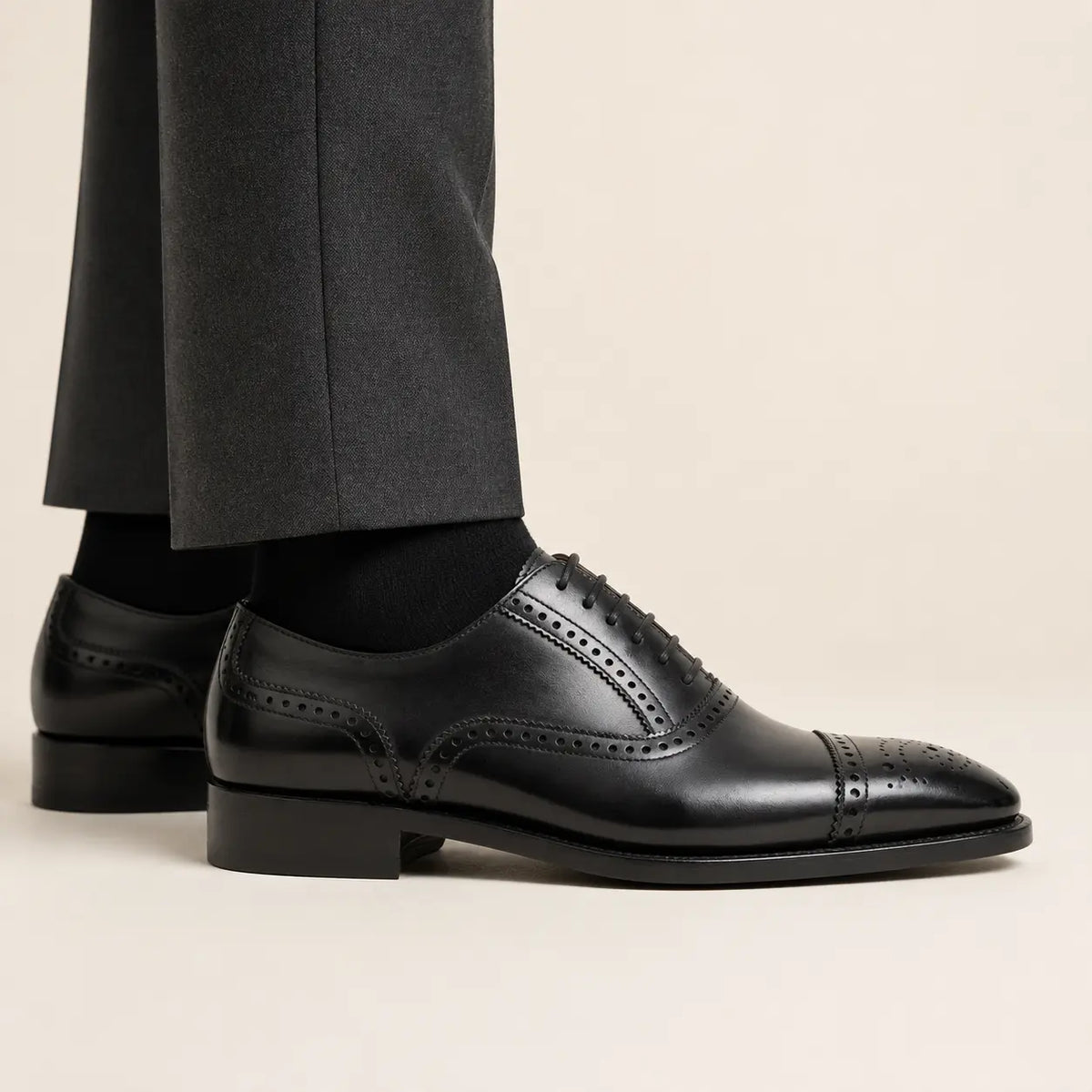DIVINCH black medallion cap-toe Oxford on foot — warm studio side profile