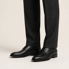 Black Minimalist Derby on foot, warm off-white studio