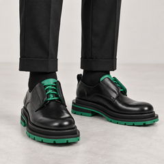 Black and green lug-sole derby shoes on foot, no shoe trees