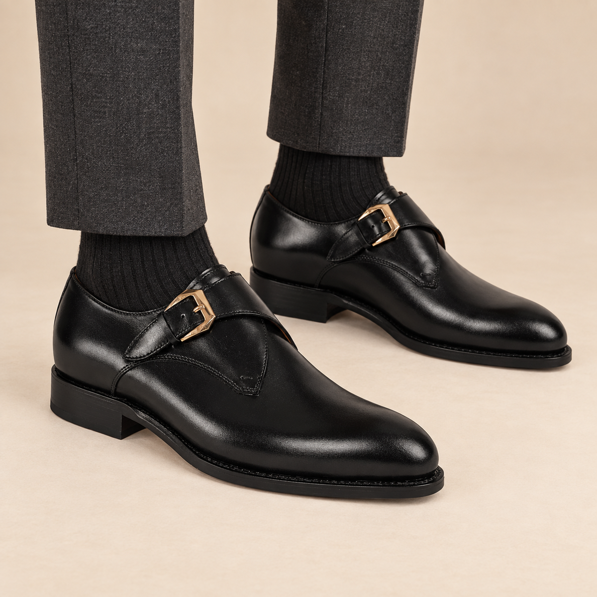 Black plain-toe single monk strap shoes with polished finish on model