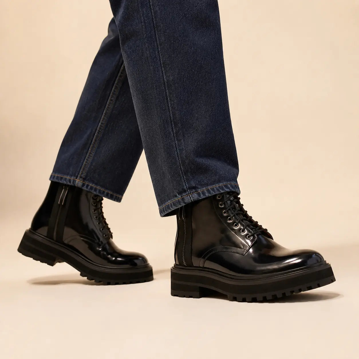 Black Polished Lace-Up Lug Boots — on-foot studio view with indigo denim