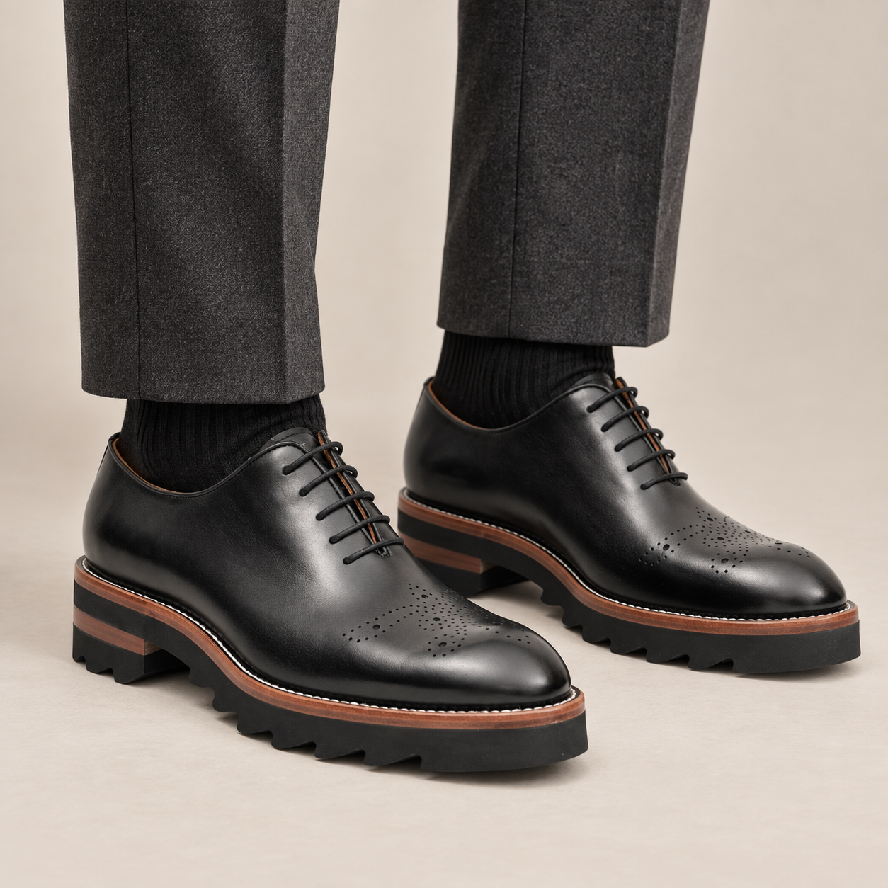 Black round-toe Oxford shoes with brown-band lug sole — premium on-foot studio view