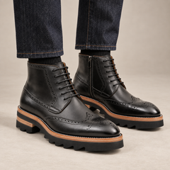 Black wingtip ankle boots with brown-band ridged sole on model lower legs, DIVINCH 7003B