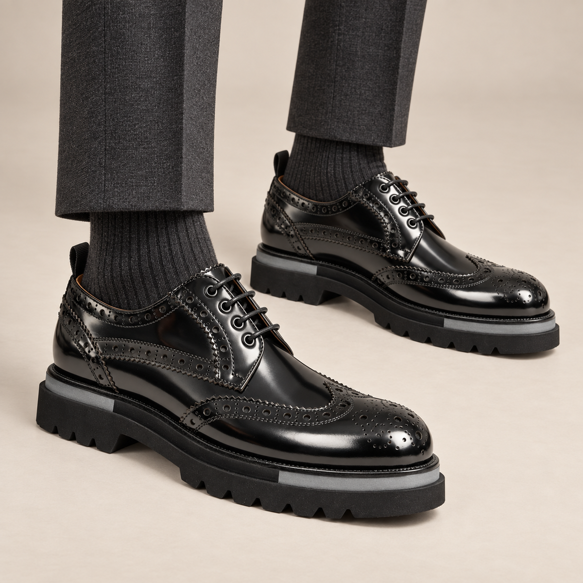 Black wingtip Derby shoes with gray sole accents — on-foot studio view