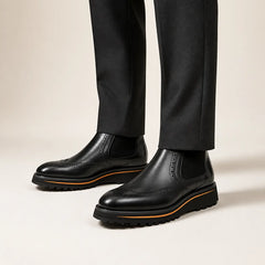 Black Wingtip Chelsea Boot on foot, warm off-white studio