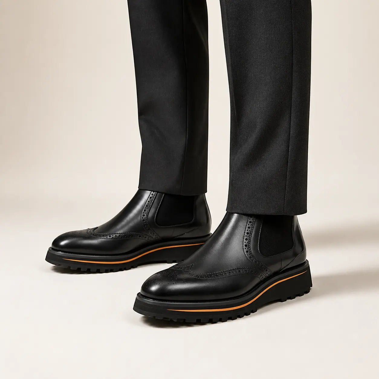 Black Wingtip Chelsea Boot on foot, warm off-white studio