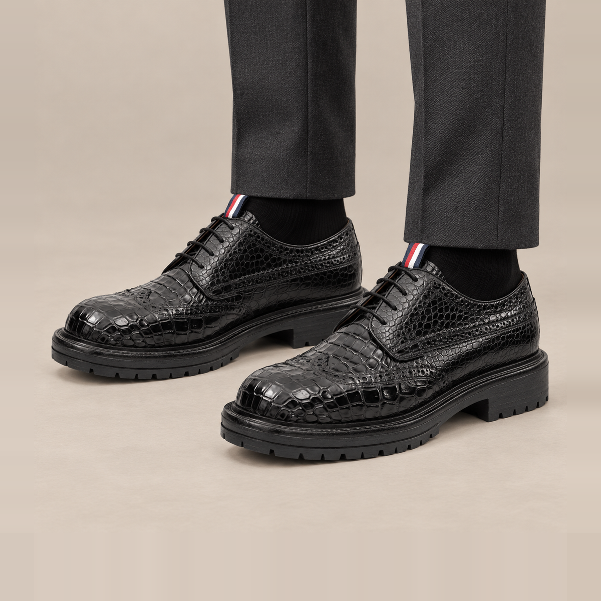 Black Scale-Pattern Wingtip Derby Shoes with Tongue Tab — on-foot studio view