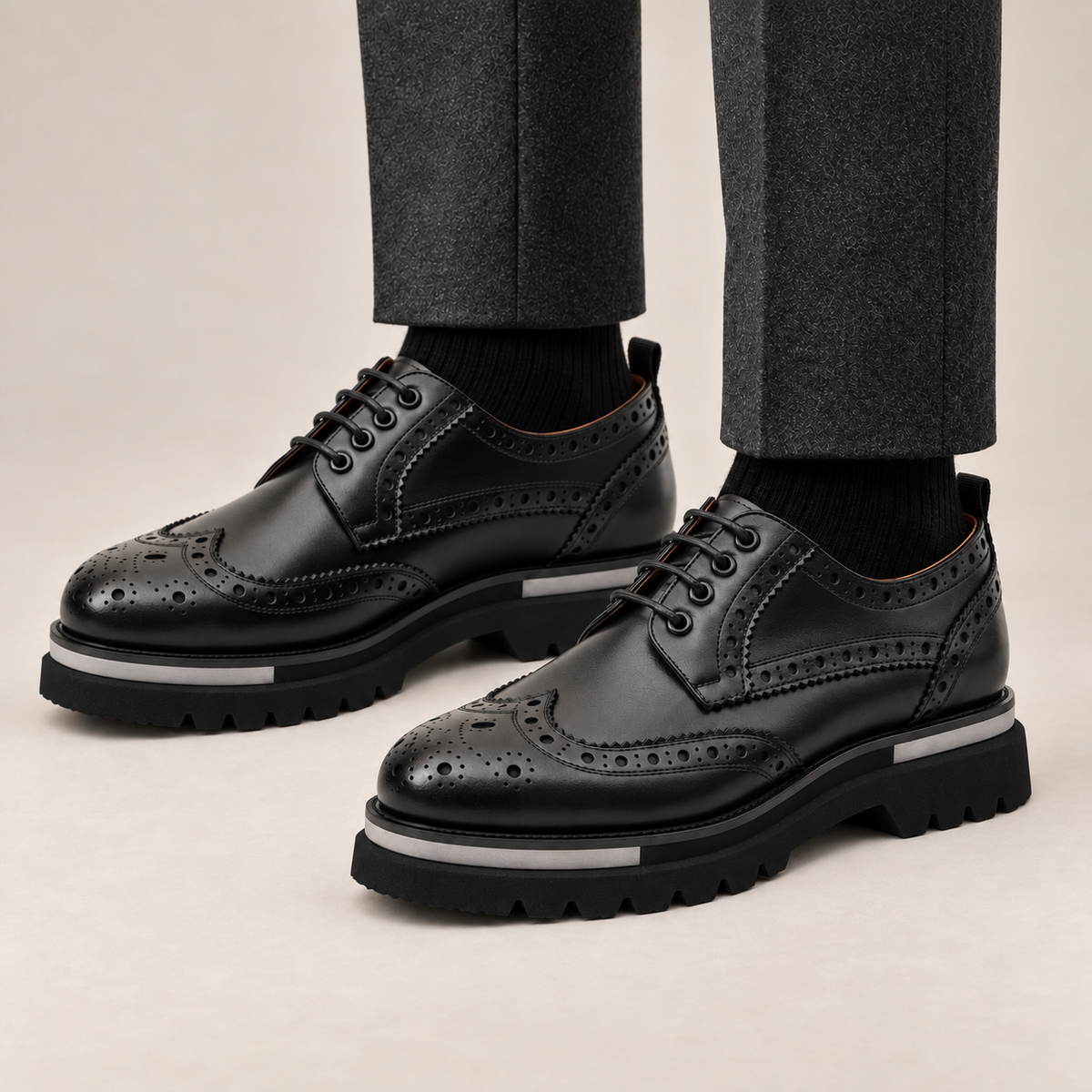 DIVINCH black glossy wingtip brogue lug-sole Derby shoes worn with tailored charcoal trousers