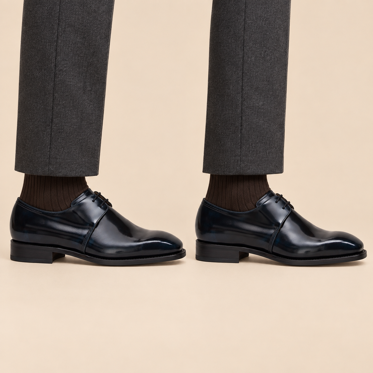 Very dark blue-black glossy plain-toe Derby shoes worn with tailored trousers