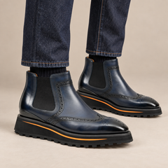 Dark blue wingtip Chelsea boots with brown-edge lug sole on model lower legs, DIVINCH 2891D