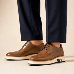 Brown brogue Derby with contrast platform sole worn with deep navy wide-leg trousers