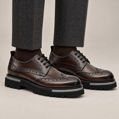 DIVINCH shaded brown glossy wingtip brogue lug-sole Derby shoes worn with tailored charcoal trousers