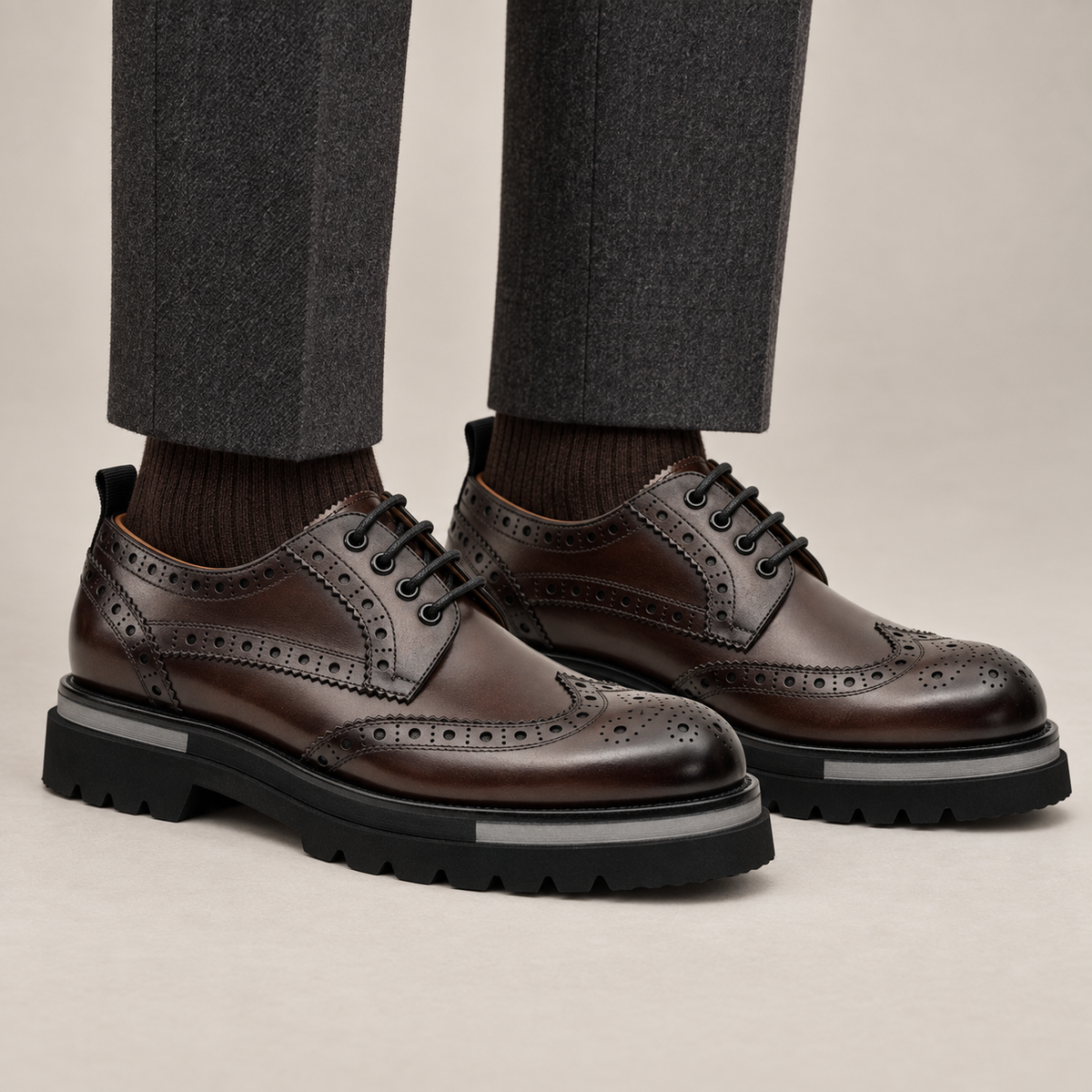 DIVINCH shaded brown glossy wingtip brogue lug-sole Derby shoes worn with tailored charcoal trousers