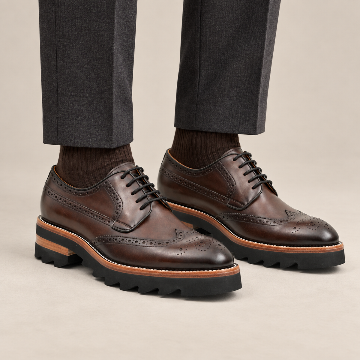 Brown wingtip Derby shoes with brown-band lug sole — premium on-foot studio view
