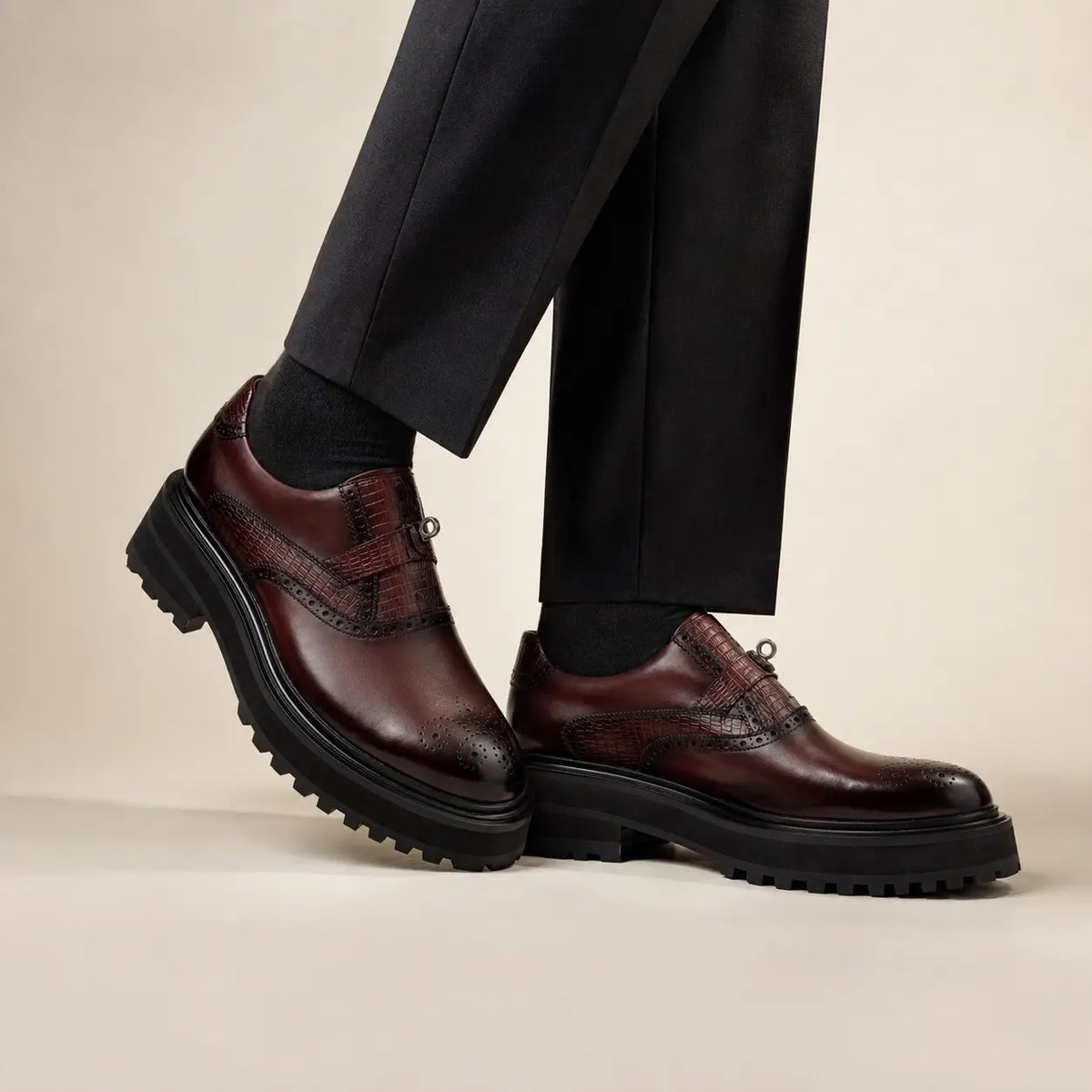 Burgundy crocodile-trim lug sole shoes on foot in studio