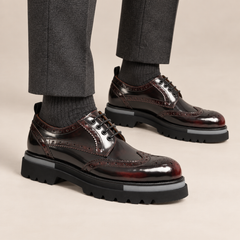 Burgundy wingtip Derby shoes with gray sole accents — on-foot studio view