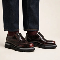 Burgundy wingtip platform Derby shoes on foot