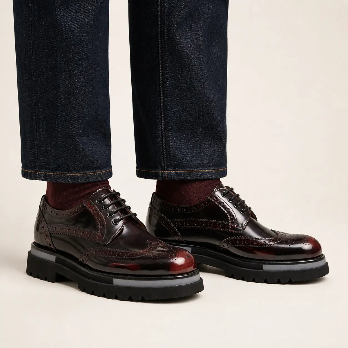 Burgundy wingtip platform Derby shoes on foot