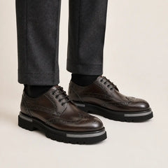 Burnished wingtip brogue lug-sole Derby shoes on foot