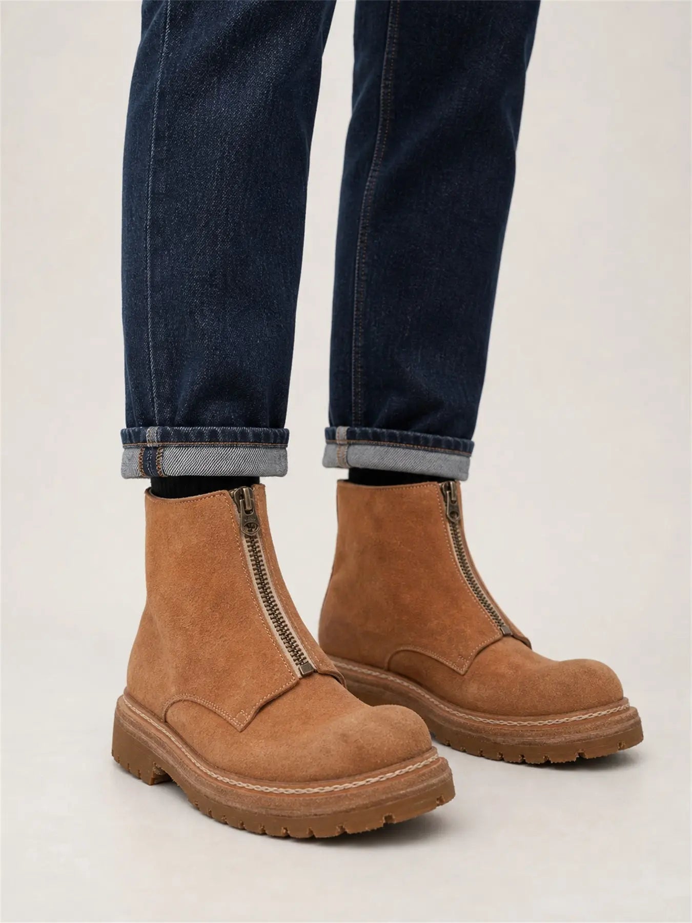 DIVINCH camel suede zip ankle boots on foot with rolled dark blue denim in studio