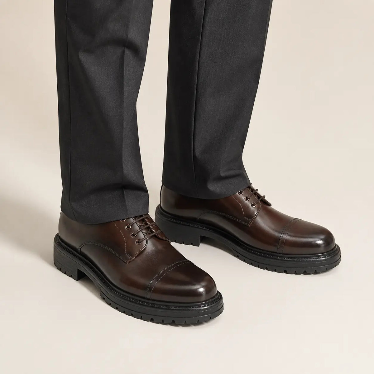 Classic Brown Cap-Toe Derby on foot, warm off-white studio
