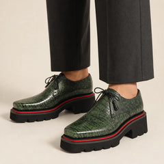 Green lizard leather Derby with elevated sole worn with charcoal wide-leg trousers