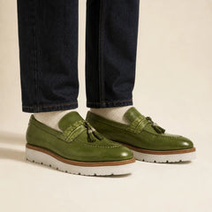 Olive green crocodile-effect tassel loafer on foot
