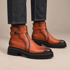 Orange-brown burnished lug sole ankle boots with harness strap on foot