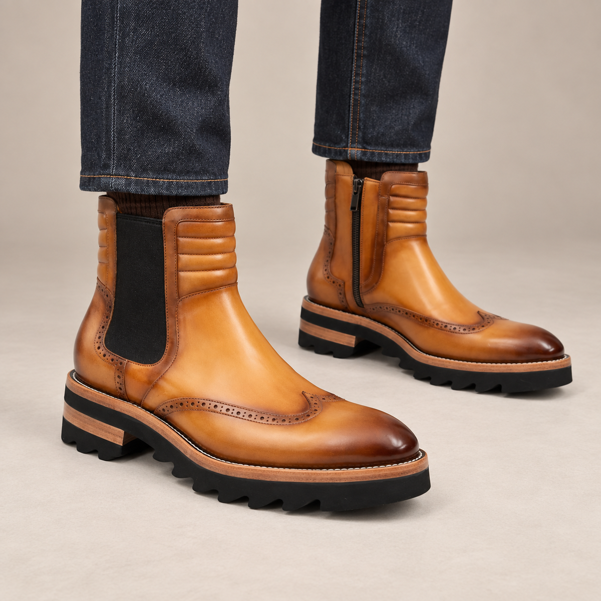 Golden tan-brown wingtip Chelsea ankle boots — on-foot studio view